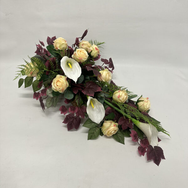 Kompozycja kwiatowa na bordowym klonie z kremowych róż i białych gumowanych kalli