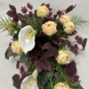 Kompozycja kwiatowa na bordowym klonie z kremowych róż i białych gumowanych kalli