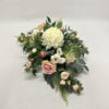 Kompozycja kwiatowa z białych chryzantem, różowych miniaturowych różyczek na liściach róży i ruskusa