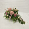 Kompozycja kwiatowa z różowych chryzantem, róż, clematis na liściach paproci
