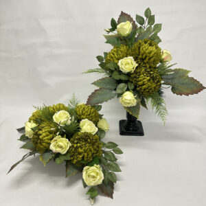 Kompozycja na dużych jesiennych liściach z dużymi zielonymi chryzantemami oraz biało-zielonymi różami w zestawie z wazonem.