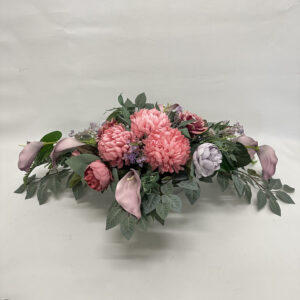 Wiązanka nagrobna z różowych chryzantem, wygaszonej fioletowej peonii na liściach róży