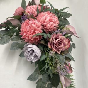 Wiązanka nagrobna z różowych chryzantem, wygaszonej fioletowej peonii na liściach róży